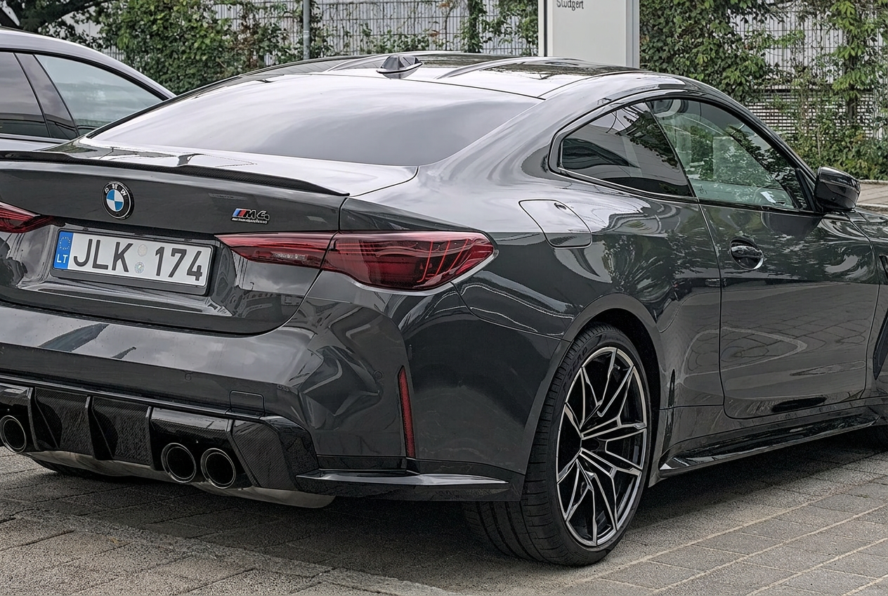 Pilkas BMW M4 Competition (G82) kupė iš galo